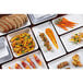 A group of rectangular white melamine bowls on a table with food.