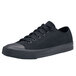 A black Shoes For Crews Delray unisex casual shoe with laces on a table.