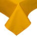 A gold rectangular tablecloth with a folded edge on a table.