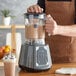 A person using an AvaMix commercial blender to make a smoothie.