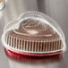 A clear plastic dome lid on a heart shaped foil bake pan.