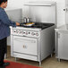 A man cooking on a Cooking Performance Group commercial gas range.