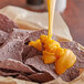 A bowl of chips with Muy Fresco Aged Cheddar nacho cheese sauce.