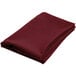 A folded burgundy cloth on a white background.