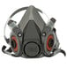 A close up of a 3M grey and black half facepiece respirator with red and black straps.