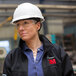 A woman wearing a 3M hard hat and glasses.