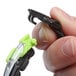 A person holding 3M Solus safety glasses with green and black accents.
