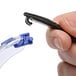 A hand holding 3M Solus safety glasses with blue and black accents and clear lenses.