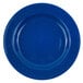 A white enamelware salad plate with a blue speckled surface and wide rim.