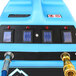 A blue rectangular object with white lines, a blue sign with white lines, and a few red lights on a blue machine.