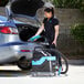 A woman using a Mytee carpet shampooer to clean the trunk of a car.