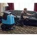 a man vacuuming a couch