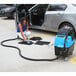 A woman using the Mytee HP60 Spyder Automotive Heated Extractor to clean a car interior.