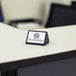 A black rectangular American Metalcraft "No Smoking" sign on a desk.