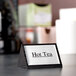 An American Metalcraft black wood "Hot Tea" sign on a table.