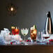 A table with Luigi Bormioli shot glasses filled with different colored drinks.