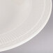 An ivory china soup bowl with an embossed rim.