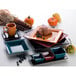 A stack of International Tableware blackberry rectangular platters on a table with a croissant and blueberries.
