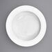 A close-up of a white porcelain pasta bowl with a white rim.