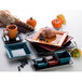 A stack of International Tableware Elite Harvest blueberry square plates on a table with a croissant and blueberries.