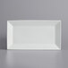 A white rectangular International Tableware porcelain platter with a wide rim.