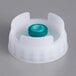 A white plastic cap with a green circle in it.