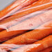 A close up of carrots in a clear plastic low density vented bag.