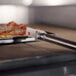 A GI Metal pan gripper lifting a rectangular pizza pan with a pizza on it.