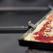 A GI Metal pan gripper lifting a pizza pan with a pizza inside.