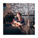 An American Metalcraft clear PVC restaurant partition on a table in a farm-to-table restaurant with a man and woman sitting at a table.