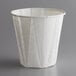 A white Genpak paper souffle and drinking cup on a gray surface.