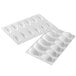 A white plastic Silikomart silicone baking mold with oval shaped cavities and a border.