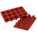 A close-up of a red Silikomart silicone baking mold with cone-shaped cavities.