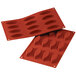 A red Silikomart silicone boat baking mold with oval shaped holes.