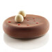 A chocolate cake baked in a Silikomart Eclipse silicone mold with white balls on top.