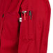A close up of a red Uncommon Chef coat with a tool pocket.