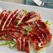 A plate of meat with Lee Kum Kee Char Siu Sauce and green onions.