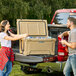 A man and woman loading CaterGator coolers into a truck.