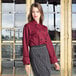 A woman in a Uncommon Chef burgundy long sleeve chef coat.