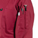 A burgundy Uncommon Chef long sleeve chef coat with a pocket and pen.