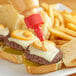 A burger with Lee Kum Kee Sriracha Mayo on a table.