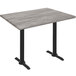 A Holland Bar Stool Greystone Wood Laminate table with black end column legs.