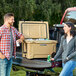 A man and woman standing next to a CaterGator outdoor cooler full of cans of beer.