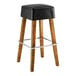 A Lancaster Table & Seating Sofia wood backless bar stool with a black vinyl seat.