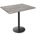 A Holland Bar Stool EnduroTop counter height table with a black base and greystone wood laminate top.
