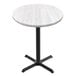 A white round Holland Bar Stool EnduroTop table with a white ash wood surface and cross base.