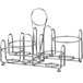 A silver metal Vollrath wire rack with four round condiment containers in it.