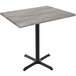 A Holland Bar Stool EnduroTop counter height table with a black base and greystone wood laminate top.