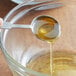 A spoon with Golden Barrel light liquid malt extract being poured into a bowl.