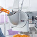 A person using an Avantco Shredder and Slicer Attachment to slice carrots.